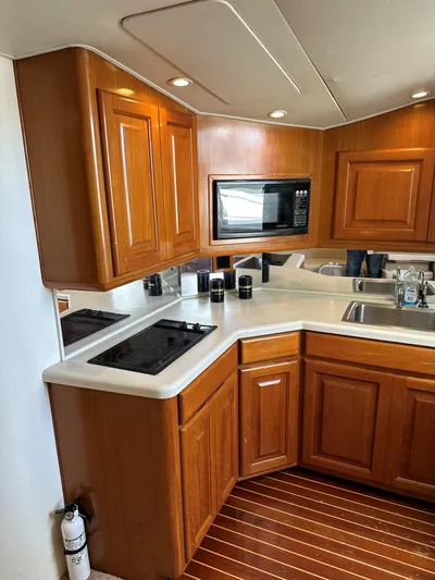 Bad Habit Yacht Photos Pics 1997 Viking 43 Open yacht kitchen with wooden cabinets and modern appliances.