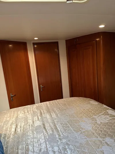 Bad Habit Yacht Photos Pics Interior cabin of 1997 Viking 43 Open yacht with wooden doors and quilted bedding.