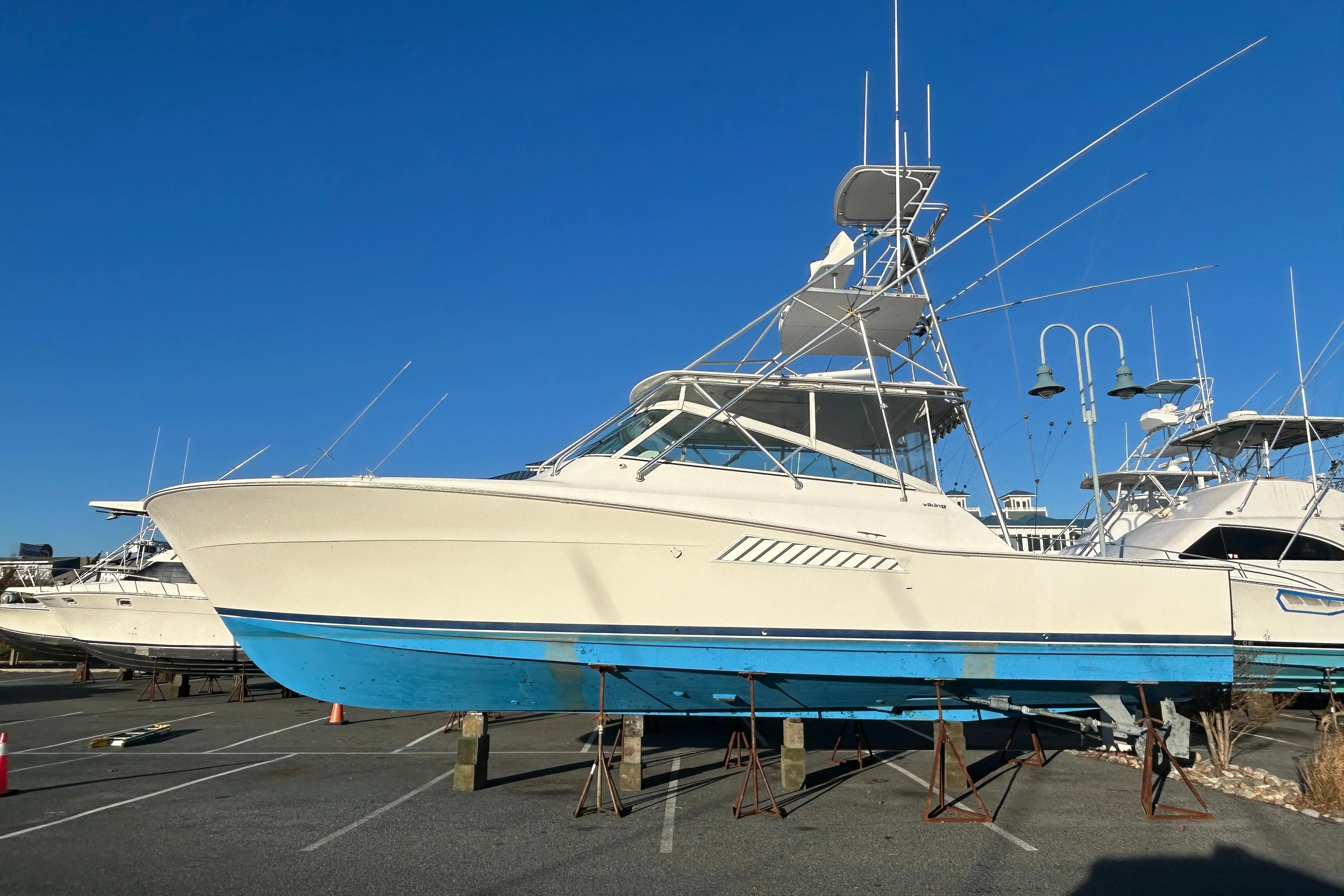 1997 Viking 43 Open yacht on dry dock, blue hull, clear sky background.