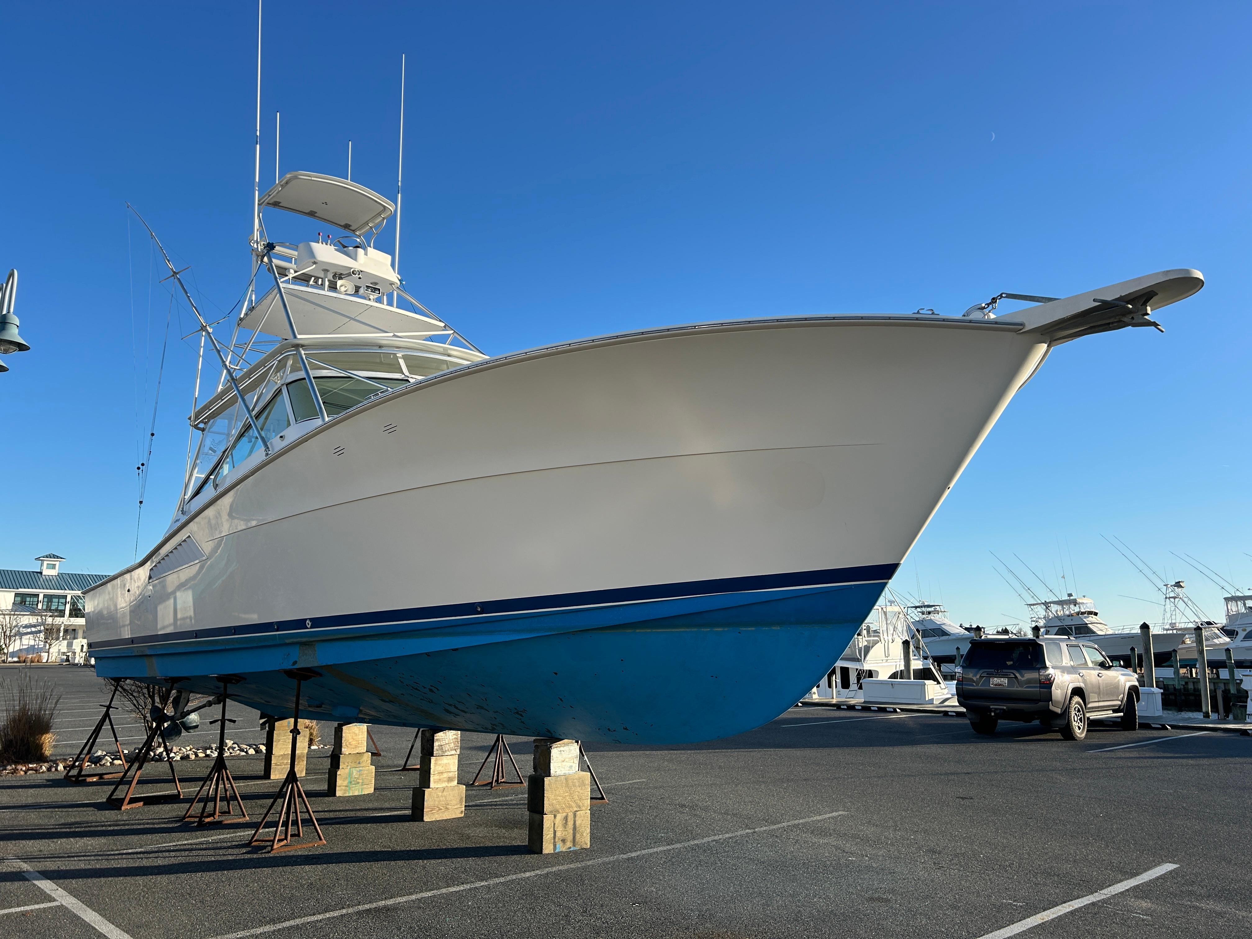 1997 Viking 43 Open yacht on stands in a marina parking lot.