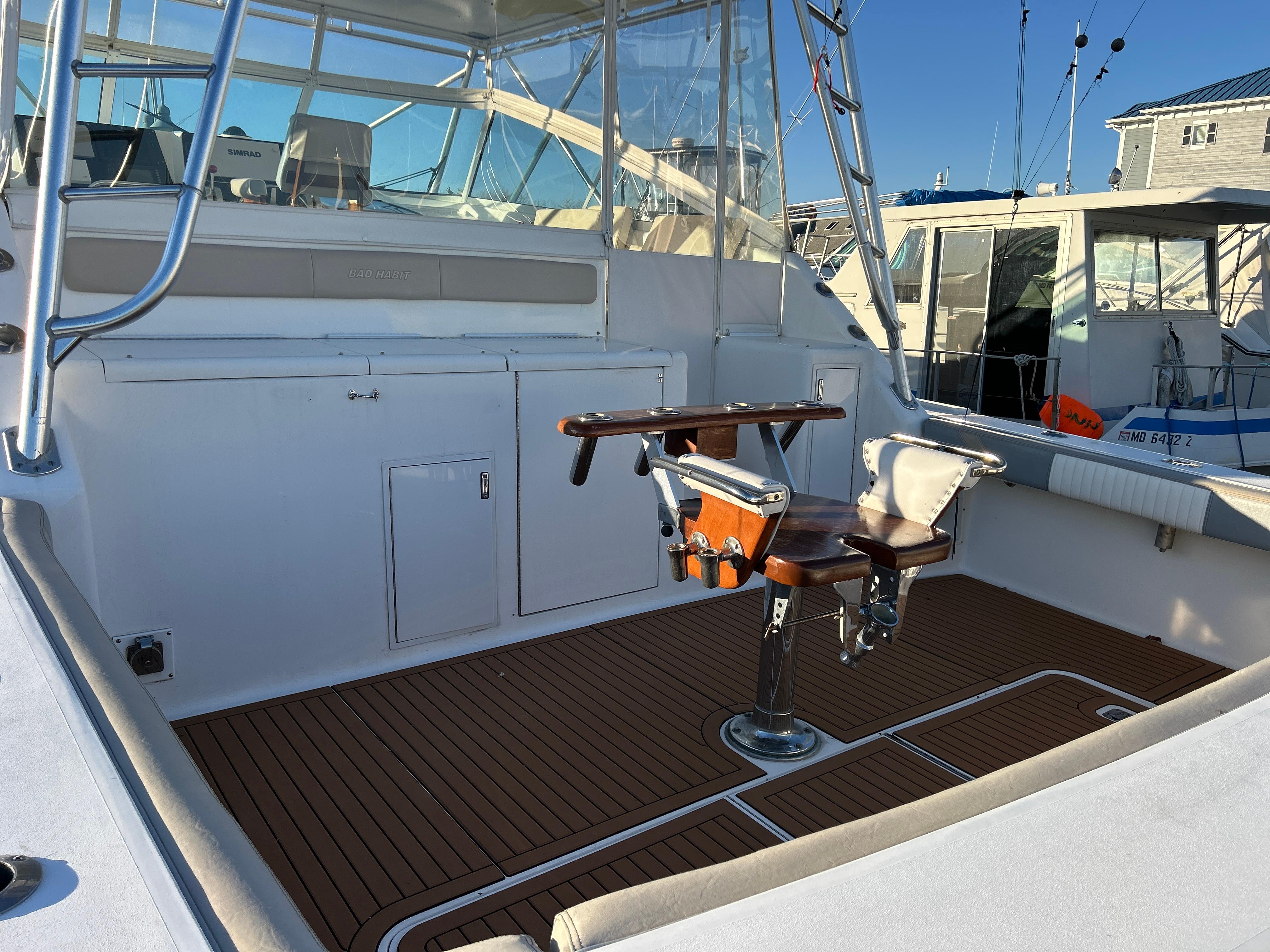 1997 Viking 43 Open boat deck with fishing chair and teak flooring.