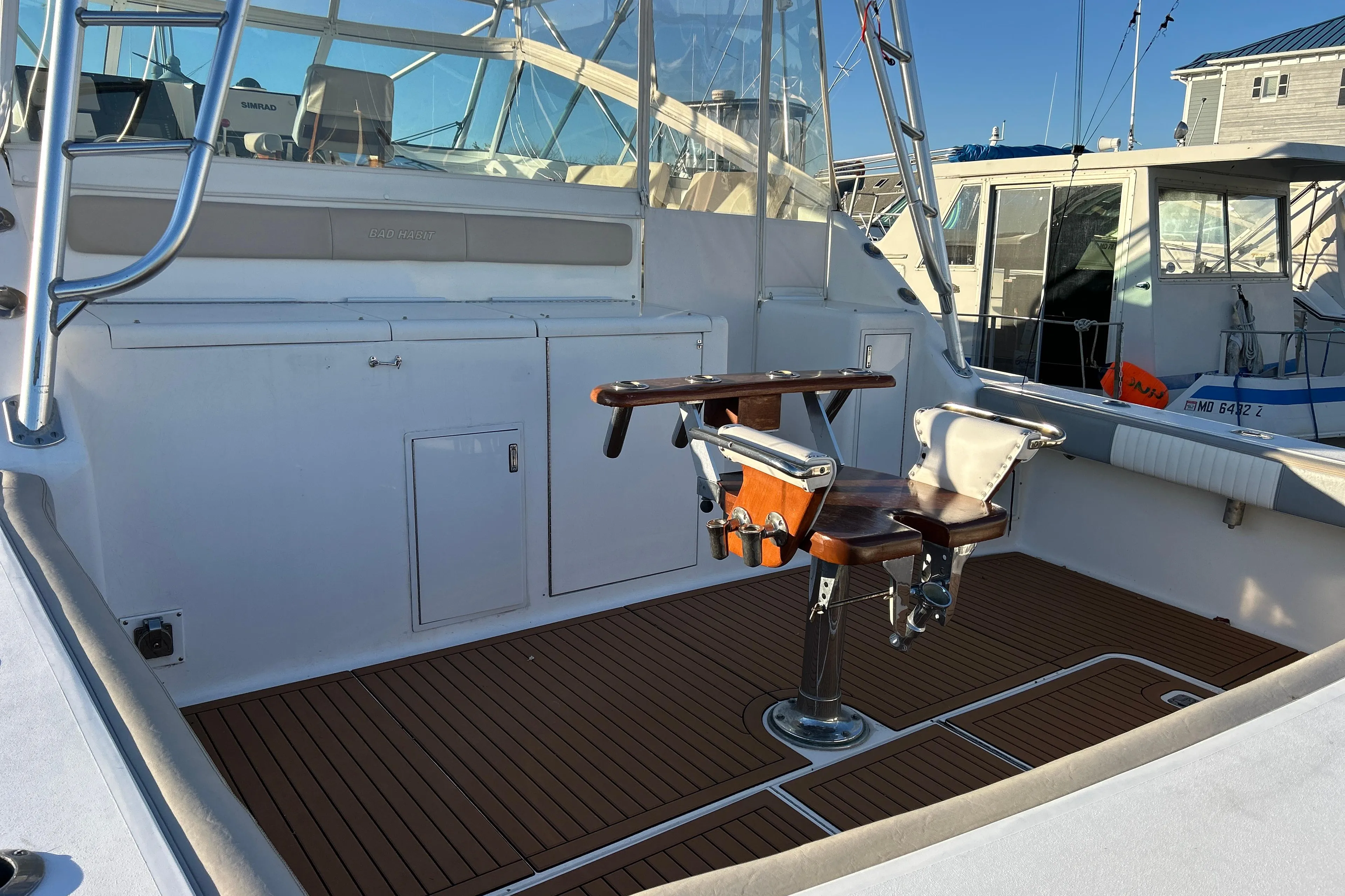 1997 Viking 43 Open boat deck with fishing chair and teak flooring.