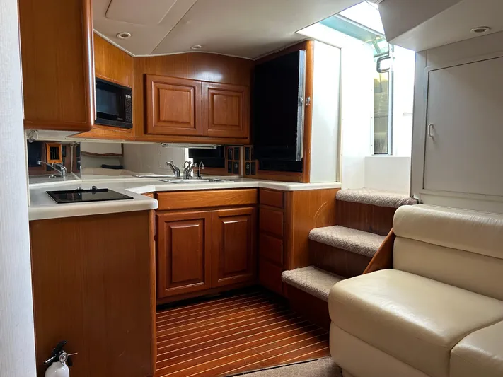 Bad Habit Yacht Photos Pics 1997 Viking 43 Open yacht interior with wooden cabinetry and modern kitchen amenities.