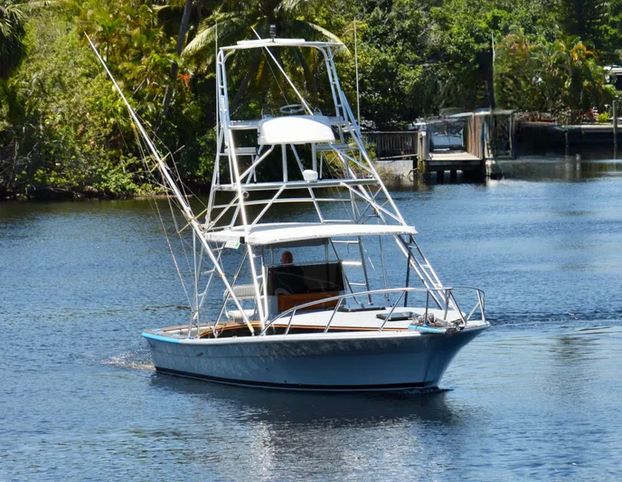  Yacht Photos Pics 2023 Strike 29 boat cruising on a calm river surrounded by lush greenery.