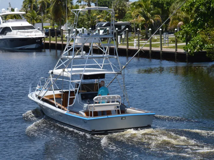  Yacht Photos Pics 2023 Strike 29 boat cruising on a calm waterway with lush greenery.