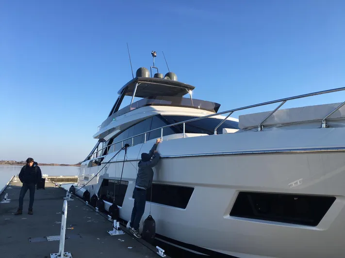  Yacht Photos Pics 2018 Ferretti Yachts 670 docked, with two people securing the vessel.