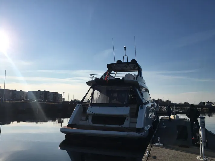  Yacht Photos Pics Ferretti Yachts 670, 2018 model, docked at a serene marina under a clear blue sky.