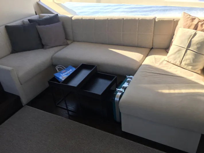  Yacht Photos Pics Luxurious interior of 2018 Ferretti Yachts 670 with beige sectional sofa and cushions.