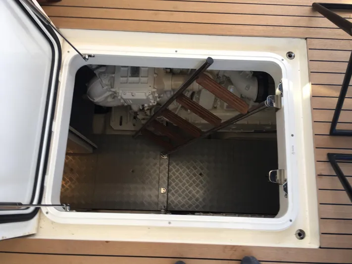  Yacht Photos Pics Engine room access hatch on 2018 Ferretti Yachts 670, featuring wooden ladder and metal flooring.