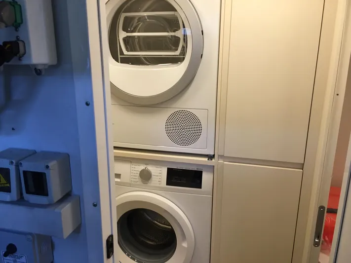  Yacht Photos Pics Laundry area with stacked washer and dryer on a 2018 Ferretti Yachts 670.