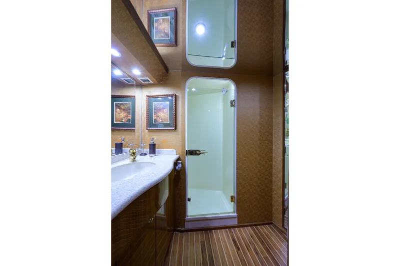  Yacht Photos Pics Luxurious bathroom in 2005 Viking 61 yacht with shower, vanity, and framed artwork.