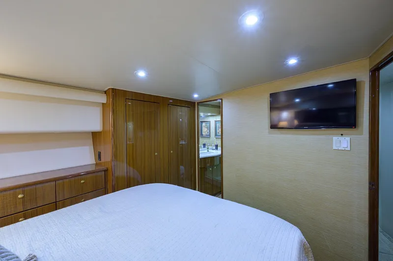  Yacht Photos Pics Luxurious bedroom interior of 2005 Viking 61 yacht with TV and wooden cabinetry.