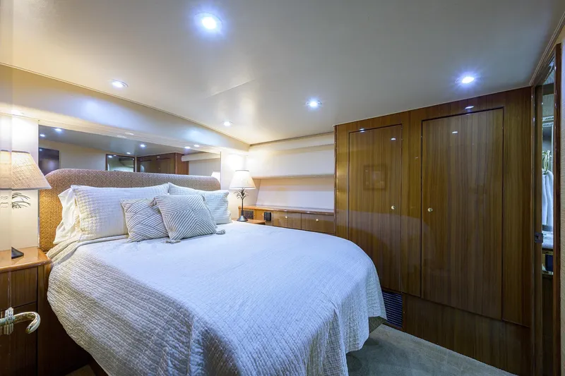  Yacht Photos Pics Luxurious bedroom interior of 2005 Viking 61 yacht with elegant wood paneling.