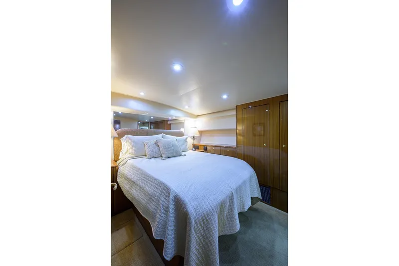  Yacht Photos Pics Luxurious bedroom interior of 2005 Viking 61 yacht with elegant bedding and ambient lighting.
