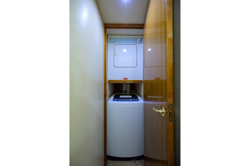  Yacht Photos Pics Compact laundry area with stacked washer and dryer in a 2005 Viking 61 yacht.
