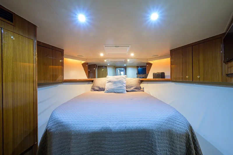  Yacht Photos Pics Luxurious cabin interior of a 2005 Viking 61 yacht with cozy bedding and wooden cabinetry.