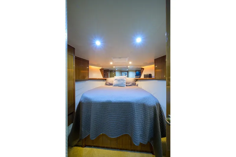  Yacht Photos Pics Luxurious bedroom interior of 2005 Viking 61 yacht with cozy lighting and elegant decor.