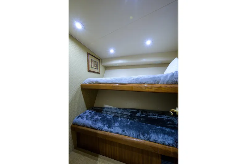  Yacht Photos Pics Bunk beds in 2005 Viking 61 yacht cabin with cozy lighting and framed artwork.