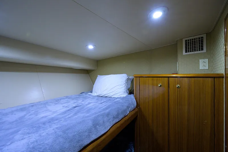  Yacht Photos Pics Cozy cabin interior of 2005 Viking 61 yacht with bed and wooden cabinet.
