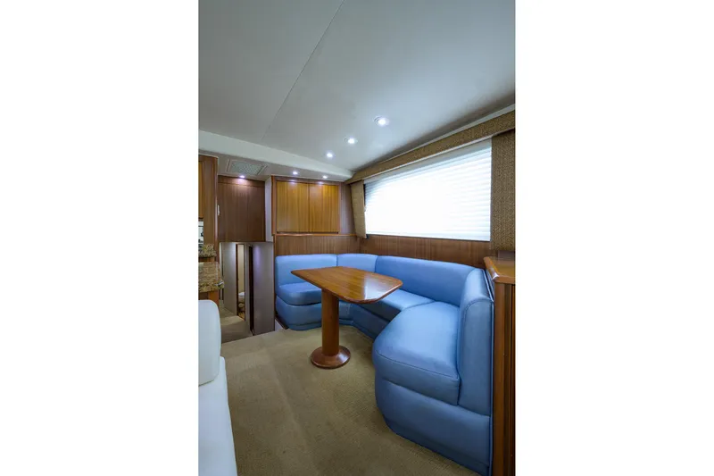  Yacht Photos Pics Interior of 2005 Viking 61 yacht with blue seating and wooden table.