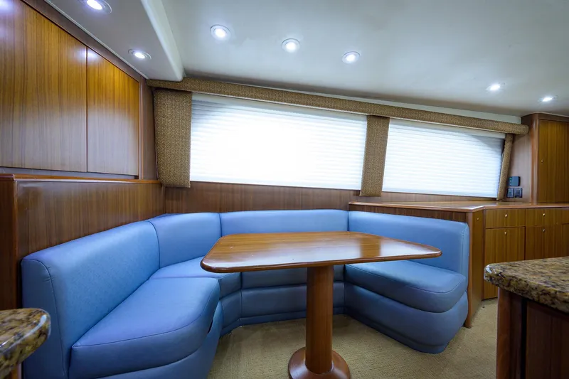  Yacht Photos Pics Luxurious 2005 Viking 61 yacht interior with blue seating and wooden table.