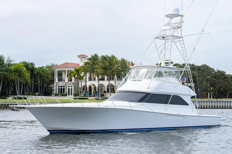  Yacht Photos Pics 2005 Viking 61 yacht cruising near a luxurious waterfront mansion with palm trees.