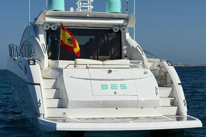Bes Yacht Photos Pics 2007 Sunseeker Predator 62 yacht with Spanish flag, anchored in clear blue waters.