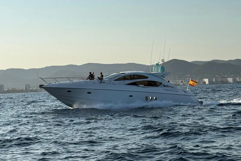 Bes Yacht Photos Pics 2007 Sunseeker Predator 62 yacht cruising on open water with mountains in the background.