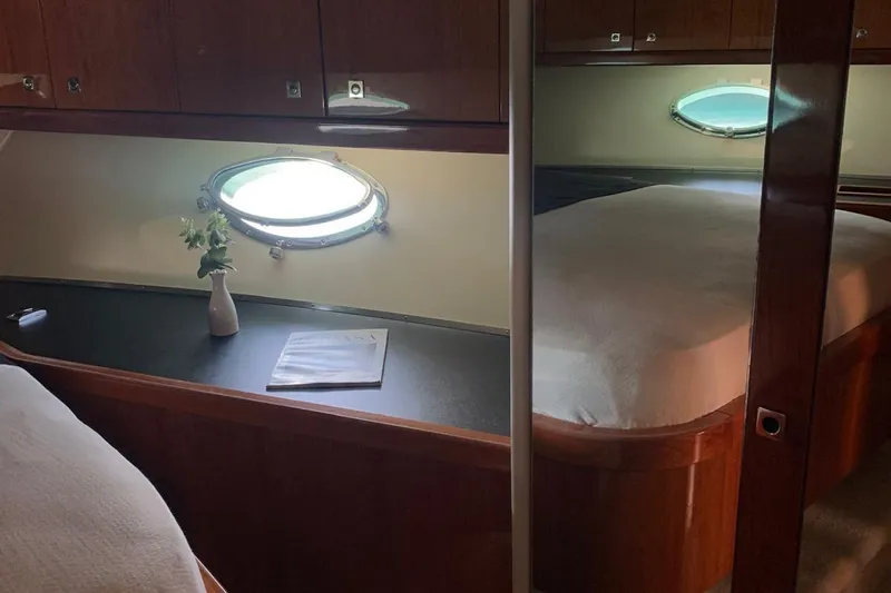 Bes Yacht Photos Pics Luxurious cabin interior of 2007 Sunseeker Predator 62 yacht with porthole and elegant decor.