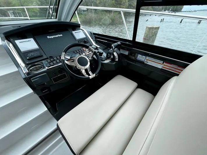 The Mabel Coe Yacht Photos Pics 2018 Monterey 360 Sport Coupe helm with Raymarine electronics, leather seating, and waterfront view.