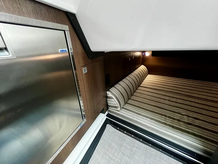The Mabel Coe Yacht Photos Pics Interior cabin of 2018 Monterey 360 Sport Coupe with bed and stainless steel fridge.