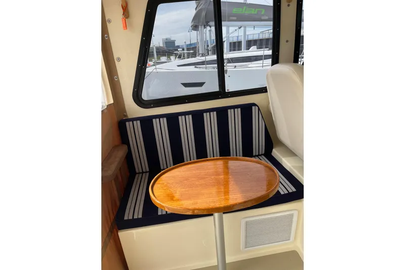  Yacht Photos Pics Interior of 2020 Eastern 27 Islander boat with striped seating and wooden table.