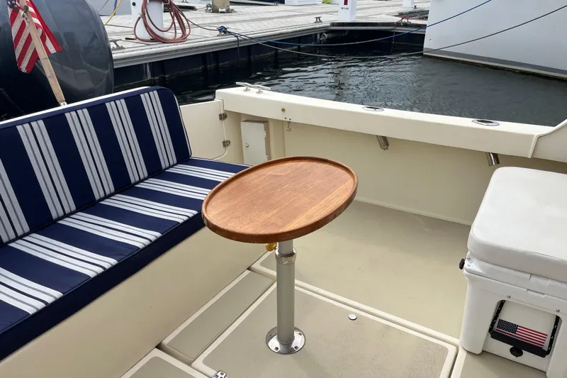 Yacht Photos Pics Cozy seating area on 2020 Eastern 27 Islander boat with striped cushions and wooden table.