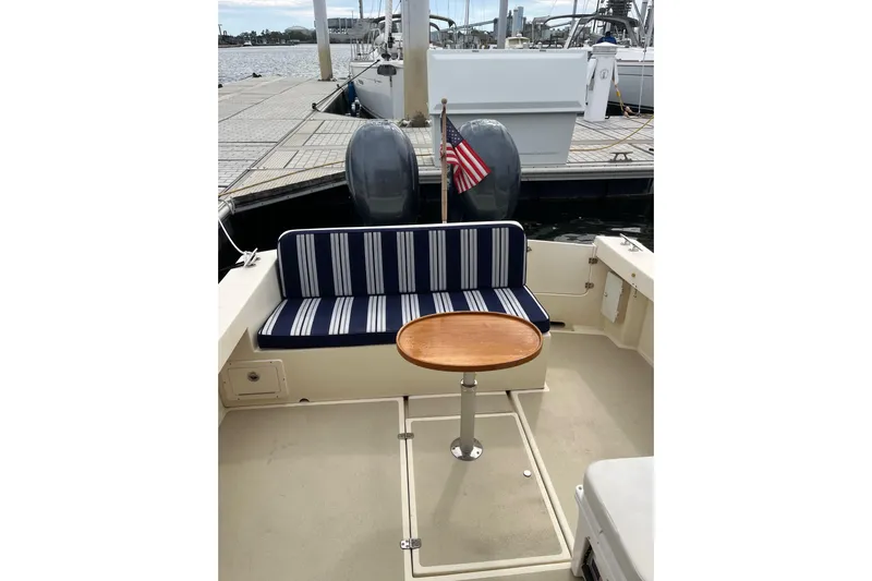  Yacht Photos Pics 2020 Eastern 27 Islander boat interior with striped seating and wooden table at dock.