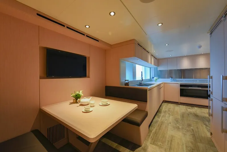  Yacht Photos Pics Modern kitchen and dining area in 2026 Majesty 120 yacht, featuring sleek design and cozy seating.