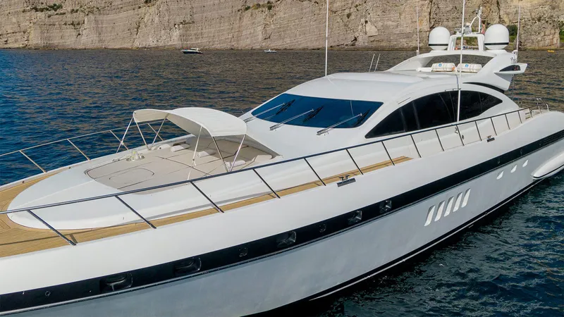 Deva I Yacht Photos Pics Luxury 2008 Mangusta 92 yacht cruising near rocky coastline.