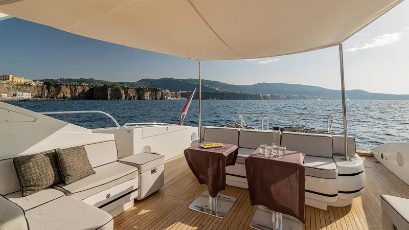 Deva I Yacht Photos Pics Luxurious 2008 Mangusta 92 yacht deck with elegant seating, overlooking scenic coastal views.