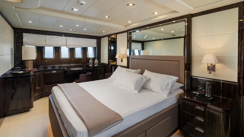 Deva I Yacht Photos Pics Luxurious bedroom interior on 2008 Mangusta 92 yacht, featuring elegant furnishings and ambient lighting.