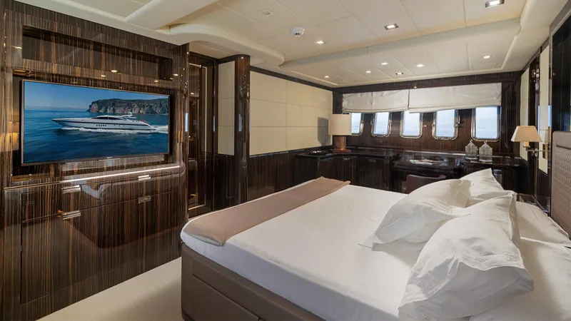 Deva I Yacht Photos Pics Luxurious bedroom interior of 2008 Mangusta 92 yacht with elegant wood finishes and modern amenities.