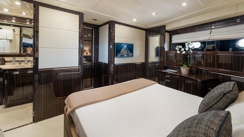Deva I Yacht Photos Pics Luxurious bedroom interior of 2008 Mangusta 92 yacht with elegant wood paneling and modern decor.