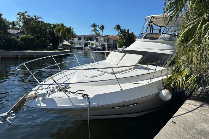  Yacht Photos Pics 2008 Sea Ray 47 Sedan Bridge yacht docked by palm trees in a sunny canal.