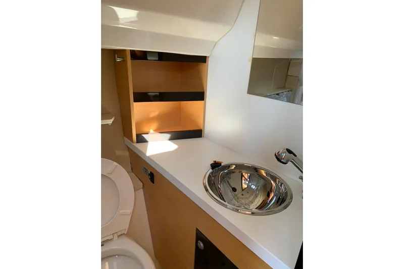  Yacht Photos Pics 2009 Crachi Endurance 33 yacht bathroom with sink, toilet, and wooden shelving.