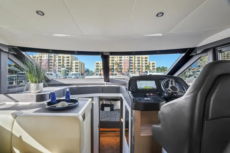  Yacht Photos Pics Interior view of 2019 Absolute 50 Fly yacht with modern helm and cityscape background.