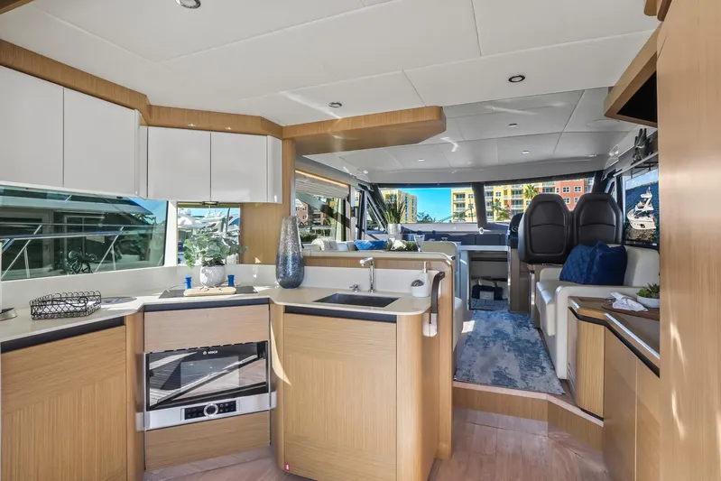  Yacht Photos Pics Luxurious interior of 2019 Absolute 50 Fly yacht with modern kitchen and seating area.