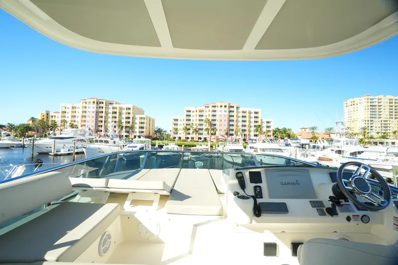  Yacht Photos Pics Flybridge view from 2019 Absolute 50 Fly yacht in a marina with buildings in the background.
