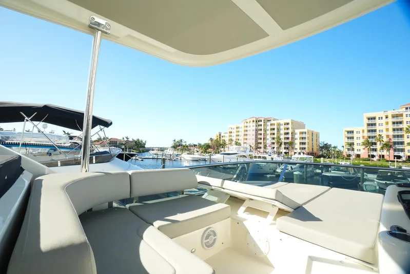  Yacht Photos Pics 2019 Absolute 50 Fly yacht with spacious deck, docked near waterfront buildings.