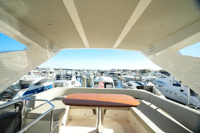  Yacht Photos Pics 2019 Absolute 50 Fly yacht interior with marina view, featuring a wooden table and seating area.