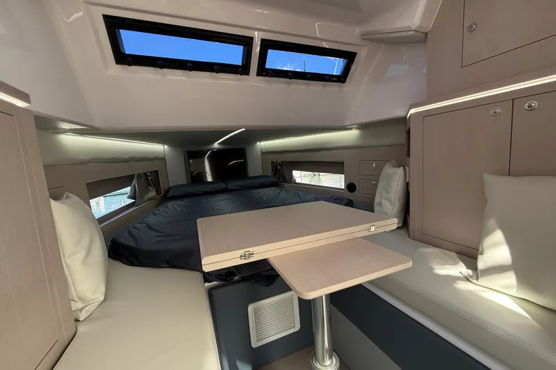  Yacht Photos Pics Interior of 2026 Ranieri CAYMAN 50.0 HARD TOP, featuring a cozy cabin with a bed and table.