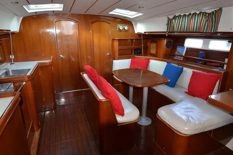  Yacht Photos Pics Interior of 1997 Beneteau Oceanis 461 yacht with wood finish and colorful cushions.