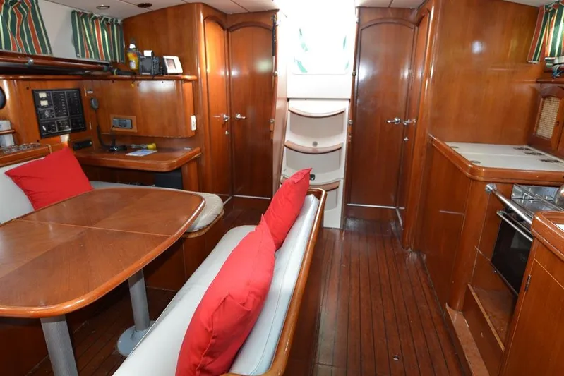  Yacht Photos Pics Interior of 1997 Beneteau Oceanis 461 yacht with wood finish and red cushions.